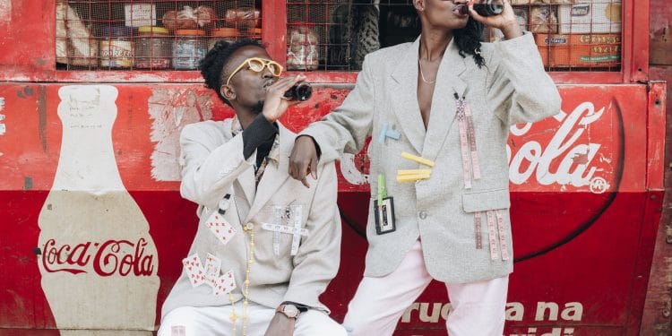 two person drinking coca cola next to a kiosk
