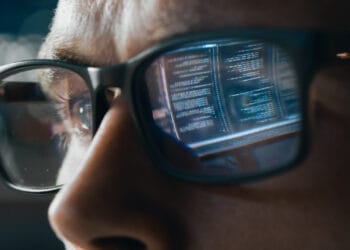 Close-up Portrait of Software Engineer Working on Computer, Line of Code Reflecting in Glasses. Developer Working on Innovative e-Commerce Application using Big Data Concept