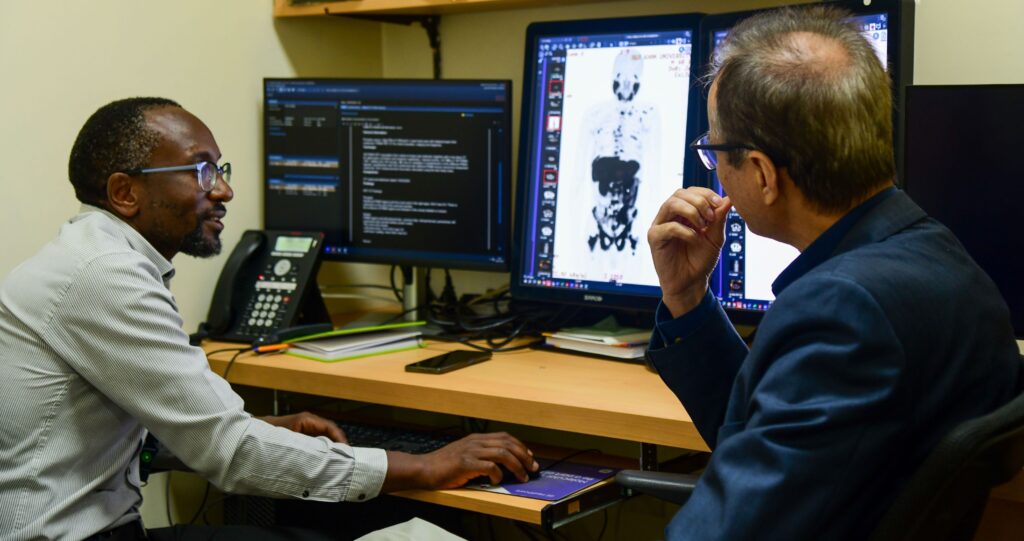 Aga Khan University Hospital Section Head, Nuclear Radiology, Dr Samuel Nguku and Chair, Department of Radiology, Dr Khalid Makhdomi analyse a scan image for one of the patients who received the Lutetium-177 PSMA therapy