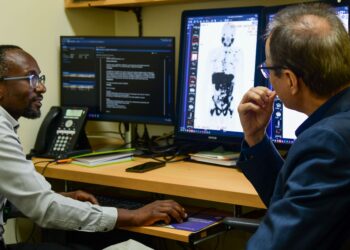 Aga Khan University Hospital Section Head, Nuclear Radiology, Dr Samuel Nguku and Chair, Department of Radiology, Dr Khalid Makhdomi analyse a scan image for one of the patients who received the Lutetium-177 PSMA therapy