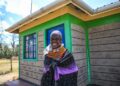 Selina, a homeowner from Nanyuki poses for a photo outside her home
