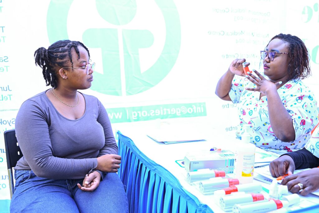 Lynnet Mwikya, an asthma patient, being taught how to use an inhaler by Veronicah Waruingi, a nurse at Gertrude's Children's Hospital