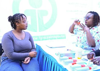 Lynnet Mwikya, an asthma patient, being taught how to use an inhaler by Veronicah Waruingi, a nurse at Gertrude's Children's Hospital