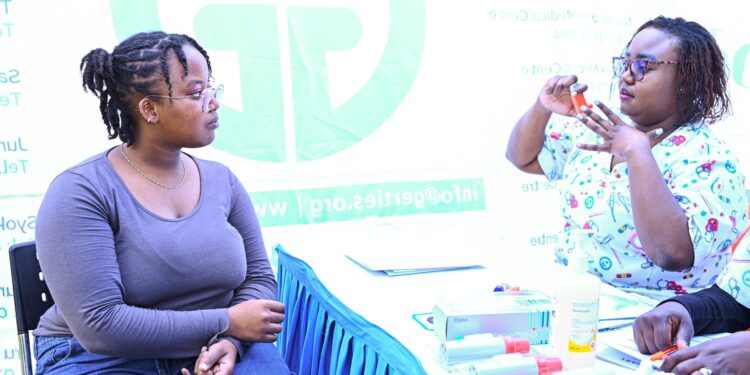 Lynnet Mwikya, an asthma patient, being taught how to use an inhaler by Veronicah Waruingi, a nurse at Gertrude's Children's Hospital